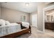 Comfortable bedroom featuring neutral walls, carpet, and updated fixtures, adjacent to the en suite bathroom at 10145 Deerfield St, Firestone, CO 80504