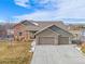 Charming home featuring stone accents, a three-car garage, and a manicured front yard at 10145 Deerfield St, Firestone, CO 80504