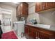 Functional laundry room features wooden cabinets, a washer and dryer, and a sink at 10145 Deerfield St, Firestone, CO 80504