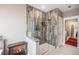 Bathroom shower featuring stylish gray tiles, a glass door, and a television mounted on the wall at 10145 Deerfield St, Firestone, CO 80504