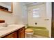 Bathroom with green bathtub and white tile walls at 7291 Bryant St, Westminster, CO 80030