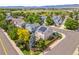 Aerial view of a neighborhood with lush green trees, single-Gathering homes, and mountain views in the distance at 9810 Mulberry Way, Highlands Ranch, CO 80129