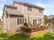 The house has a raised wood deck with potted plants, outdoor seating, and a well-maintained lawn at 9810 Mulberry Way, Highlands Ranch, CO 80129