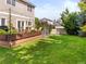 Spacious backyard with a well-maintained lawn, a wooden deck, and mature trees at 9810 Mulberry Way, Highlands Ranch, CO 80129
