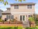The house has a raised wood deck with potted plants, outdoor seating, and a well-maintained lawn at 9810 Mulberry Way, Highlands Ranch, CO 80129