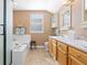 Bright bathroom features dual sinks, tile floors, and a soaking tub with a shower at 9810 Mulberry Way, Highlands Ranch, CO 80129