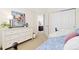 Bright bedroom featuring a patterned daybed, white dresser with floral art, and an open doorway at 9810 Mulberry Way, Highlands Ranch, CO 80129