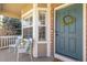Inviting front porch with comfortable seating, brick accents, and a blue front door with a wreath at 9810 Mulberry Way, Highlands Ranch, CO 80129