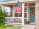 Inviting front porch with white railing, brick accents, and a charming blue front door with a festive wreath at 9810 Mulberry Way, Highlands Ranch, CO 80129