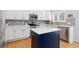Well-appointed kitchen with white cabinets, stainless appliances, and a stylish navy-blue island at 9810 Mulberry Way, Highlands Ranch, CO 80129