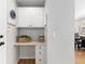 A charming office nook with white cabinets, a built-in desk, storage drawers, and an adjacent dining area at 9810 Mulberry Way, Highlands Ranch, CO 80129