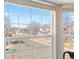Window view of a residential street with houses, trees, and a clear blue sky in the background at 9810 Mulberry Way, Highlands Ranch, CO 80129