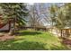 Spacious backyard with lush lawn, trees, and a wooden fence at 6431 Freeport Dr, Highlands Ranch, CO 80130
