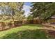 Large fenced backyard with mature trees and a well-manicured lawn at 6431 Freeport Dr, Highlands Ranch, CO 80130