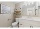 Well-appointed half bathroom featuring a white vanity, decorative mirror, and modern fixtures at 6431 Freeport Dr, Highlands Ranch, CO 80130