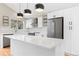 Modern white kitchen with quartz countertops, stainless appliances, and geometric backsplash at 6431 Freeport Dr, Highlands Ranch, CO 80130