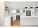 Bright kitchen features white cabinets, an island, modern appliances and geometric backsplash at 6431 Freeport Dr, Highlands Ranch, CO 80130