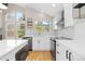 Well-lit kitchen features stainless appliances, white cabinets, and geometric backsplash at 6431 Freeport Dr, Highlands Ranch, CO 80130