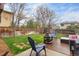 Private backyard with a wooden deck, seating, a fire pit, and a well-maintained lawn at 12606 Fairfax St, Thornton, CO 80241