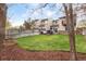 Spacious backyard with a well-manicured lawn, wooden deck, cozy seating, and privacy fence at 12606 Fairfax St, Thornton, CO 80241