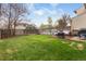 Large, private backyard with a wood deck, fire pit, and green lawn, ideal for relaxing and entertaining at 12606 Fairfax St, Thornton, CO 80241