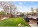 Beautiful backyard featuring a wooden deck, fire pit, and lush green lawn, perfect for outdoor enjoyment at 12606 Fairfax St, Thornton, CO 80241