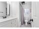 Bright bathroom with white vanity, black hardware, hexagon tile, and shower with modern fixtures at 12606 Fairfax St, Thornton, CO 80241