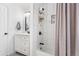 Modern bathroom featuring a white vanity, shower with unique storage, and neutral-toned shower curtain at 12606 Fairfax St, Thornton, CO 80241