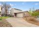 Two-story home with brick accents, attached garage, front yard with rock landscaping and extended driveway at 12606 Fairfax St, Thornton, CO 80241