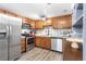Updated kitchen features stainless steel appliances, stylish backsplash, ample cabinet space, and hardwood floors at 12606 Fairfax St, Thornton, CO 80241
