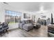 Open living area with large windows, hardwood floors, and a modern sectional sofa at 12606 Fairfax St, Thornton, CO 80241