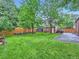 Spacious backyard featuring a lush lawn, mature trees, rock wall and convenient garage at 1351 Brentwood St, Lakewood, CO 80214