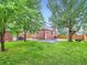 Expansive backyard with lush grass, mature trees, brick home, and convenient garage at 1351 Brentwood St, Lakewood, CO 80214