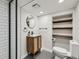 Modern bathroom with wood vanity, a glass-enclosed shower, and open shelving at 1351 Brentwood St, Lakewood, CO 80214