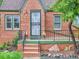 Charming front entrance featuring a brick facade, secure iron gate, and landscaped garden at 1351 Brentwood St, Lakewood, CO 80214