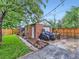 Detached brick garage featuring covered vehicles, landscaping, and a private fenced yard at 1351 Brentwood St, Lakewood, CO 80214