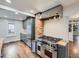 Modern kitchen featuring stainless steel appliances, a brick accent wall, and hardwood floors at 1351 Brentwood St, Lakewood, CO 80214