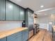 Renovated kitchen showcasing stainless steel appliances, butcher block countertops, and stylish gray cabinetry at 1351 Brentwood St, Lakewood, CO 80214