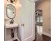 Convenient powder room featuring a classic sink and mirror, adjacent to a living space at 1351 Brentwood St, Lakewood, CO 80214