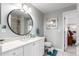 Neutral bathroom featuring a vanity with white cabinets, a round mirror, and a separate toilet at 5271 N Mesa Dr, Castle Rock, CO 80108