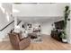 Bright living room with hardwood floors, a fireplace, a staircase, and an oversized sectional sofa at 5271 N Mesa Dr, Castle Rock, CO 80108