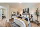Bright bedroom featuring a cozy bed with decorative pillows and wood floors at 1183 S Pierson Ct, Denver, CO 80232