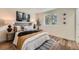 Bright bedroom featuring a cozy bed with decorative pillows, wood floors, and a large window at 1183 S Pierson Ct, Denver, CO 80232