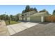 Angle view of green two-story home featuring a large driveway and lush landscaped front yard at 1183 S Pierson Ct, Denver, CO 80232