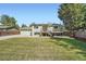Home exterior with deck, backyard, green lawn and privacy fence at 1183 S Pierson Ct, Denver, CO 80232