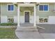 Close up of the two-story home's front porch featuring updated white columns and a gray front door at 1183 S Pierson Ct, Denver, CO 80232