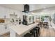Modern kitchen features white cabinets and a black range hood with a spacious island at 1183 S Pierson Ct, Denver, CO 80232