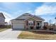 Charming single-story home featuring stone accents, a two-car garage, and a well-maintained front yard at 209 Falmouth St, Castle Rock, CO 80104