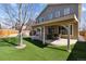 Large, private backyard featuring artificial turf, stone patio, and covered outdoor dining area at 4935 S Zephyr St, Littleton, CO 80123