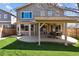 A fenced backyard featuring artificial grass, a patio, and a covered outdoor dining area at 4935 S Zephyr St, Littleton, CO 80123